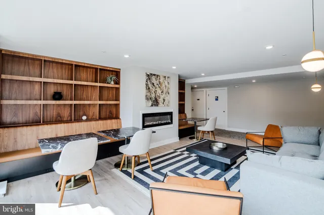 a living room with furniture a rug and a bookshelf