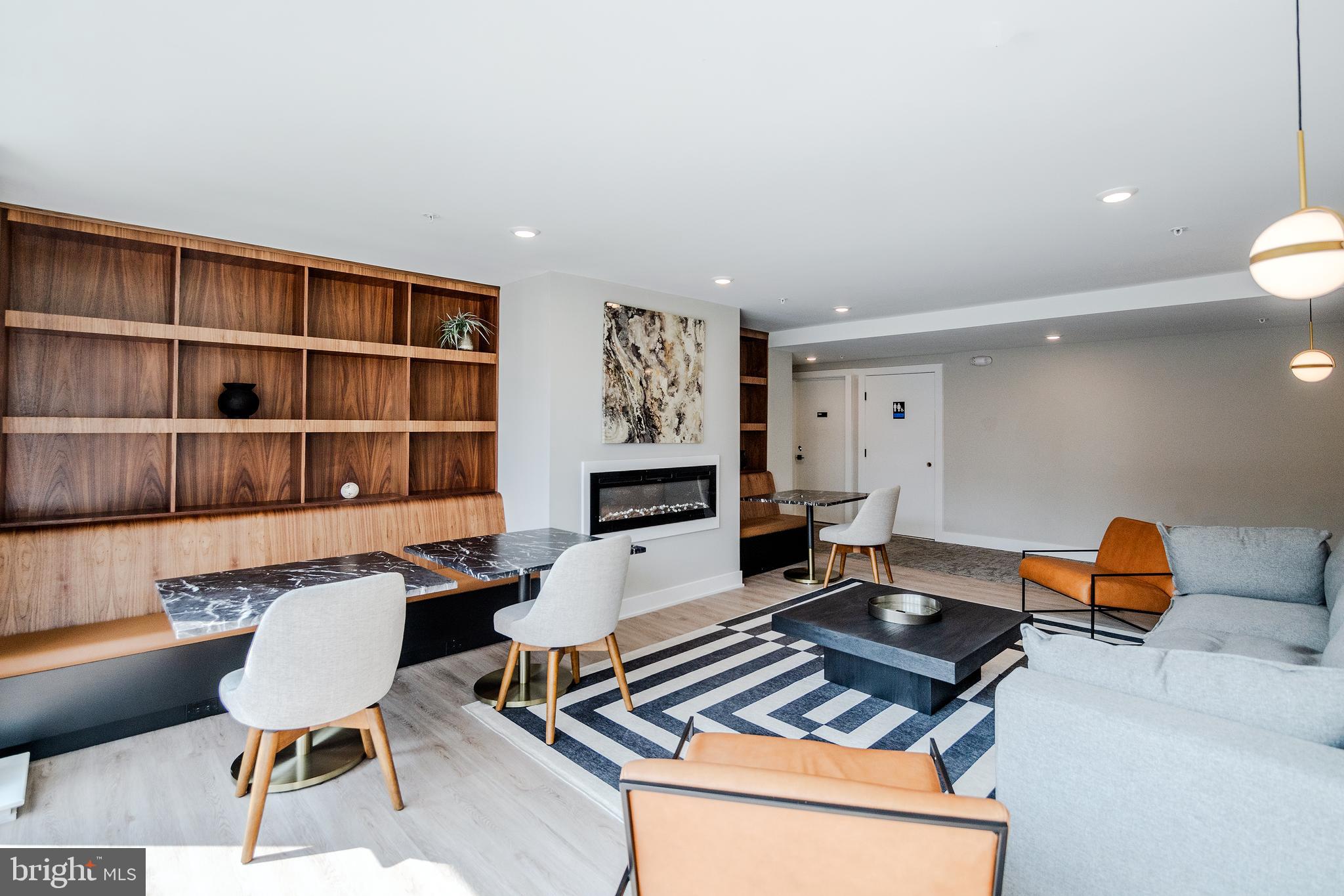 6604 Ridge Avenue, Unit 311 Philadelphia, PA 19128 - Photo 23 of 32 a living room with furniture a rug and a bookshelf