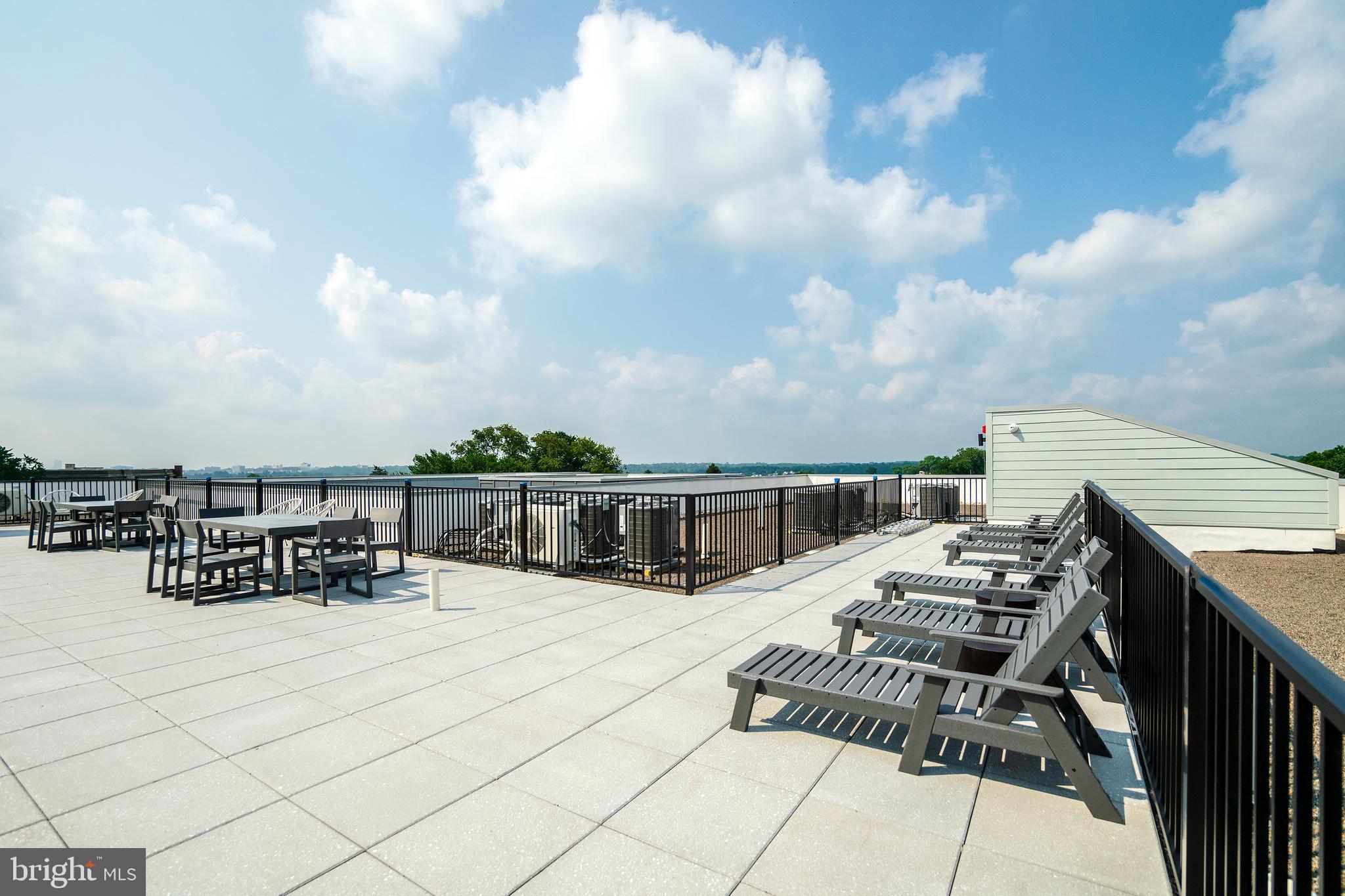 6604 Ridge Avenue, Unit 311 Philadelphia, PA 19128 - Photo 24 of 32 a view of roof deck with a barbeque and wooden stairs