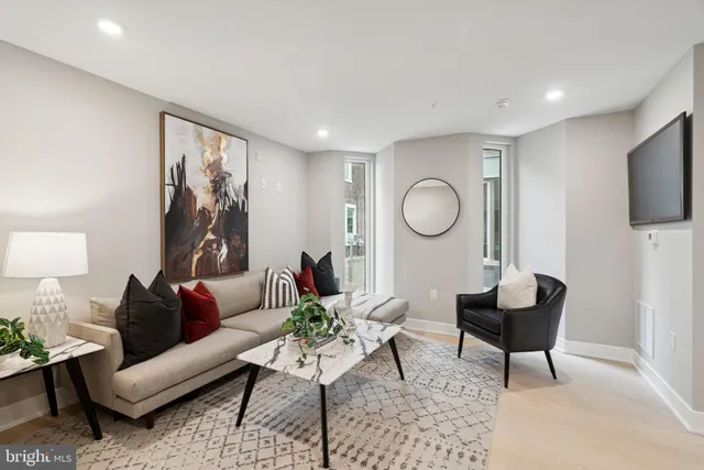 a living room with furniture a mirror and a flat screen tv