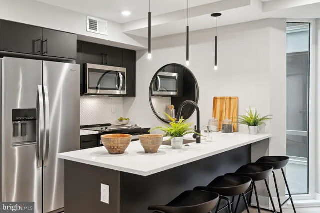 a kitchen with a table a refrigerator and cabinets