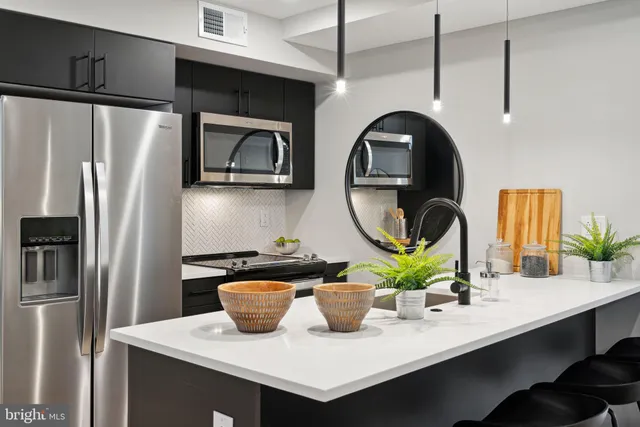 a kitchen with a refrigerator a stove a sink and a dining table