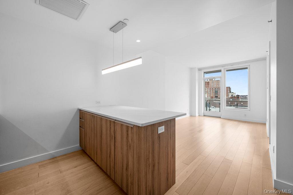 136-18 Maple Avenue, Unit 9A Queens, NY 11355 - Photo 14 of 35 Kitchen featuring a peninsula, light wood finished floors, wood finish cabinets, and modern cabinets