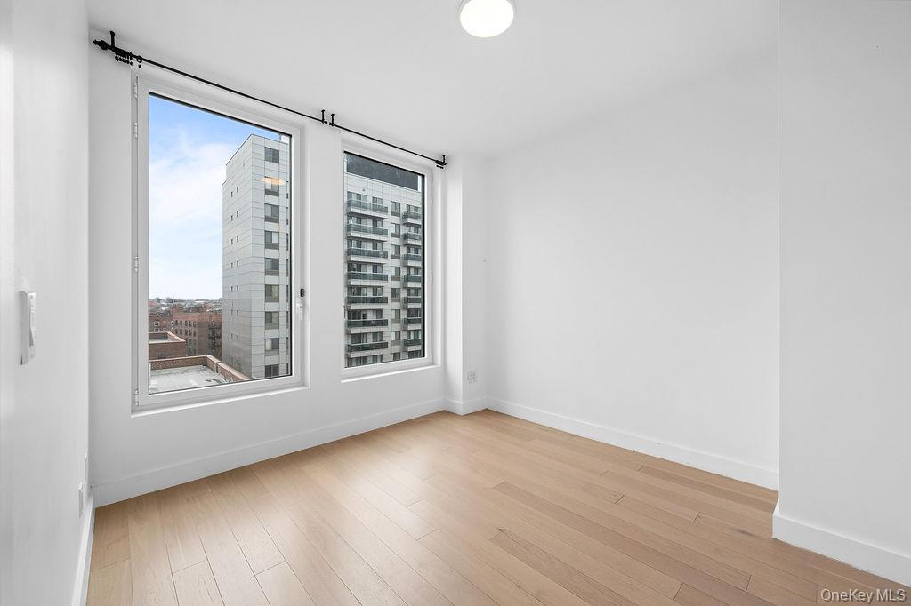 136-18 Maple Avenue, Unit 9A Queens, NY 11355 - Photo 15 of 35 Unfurnished room with light wood finished floors and baseboards