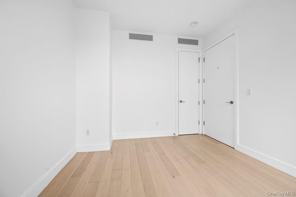 136-18 Maple Avenue, Unit 9A Queens, NY 11355 - Photo 16 of 35 Unfurnished bedroom with light wood-type flooring and baseboards