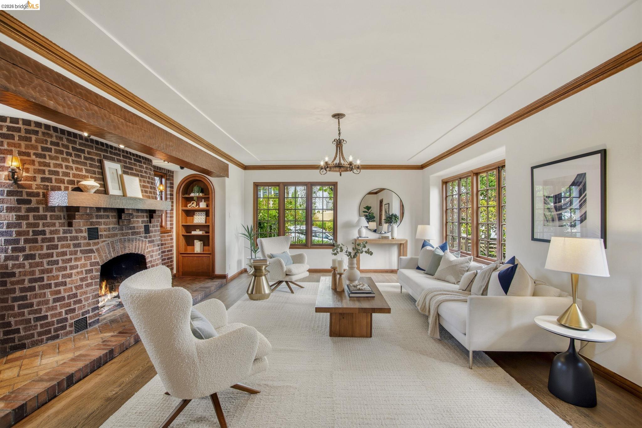 1087 Hubert Road Oakland, CA 94610 - Photo 4 of 67 Living room featuring a brick fireplace with a stone mantel, built-in arched wooden shelving, and wood-trim windows