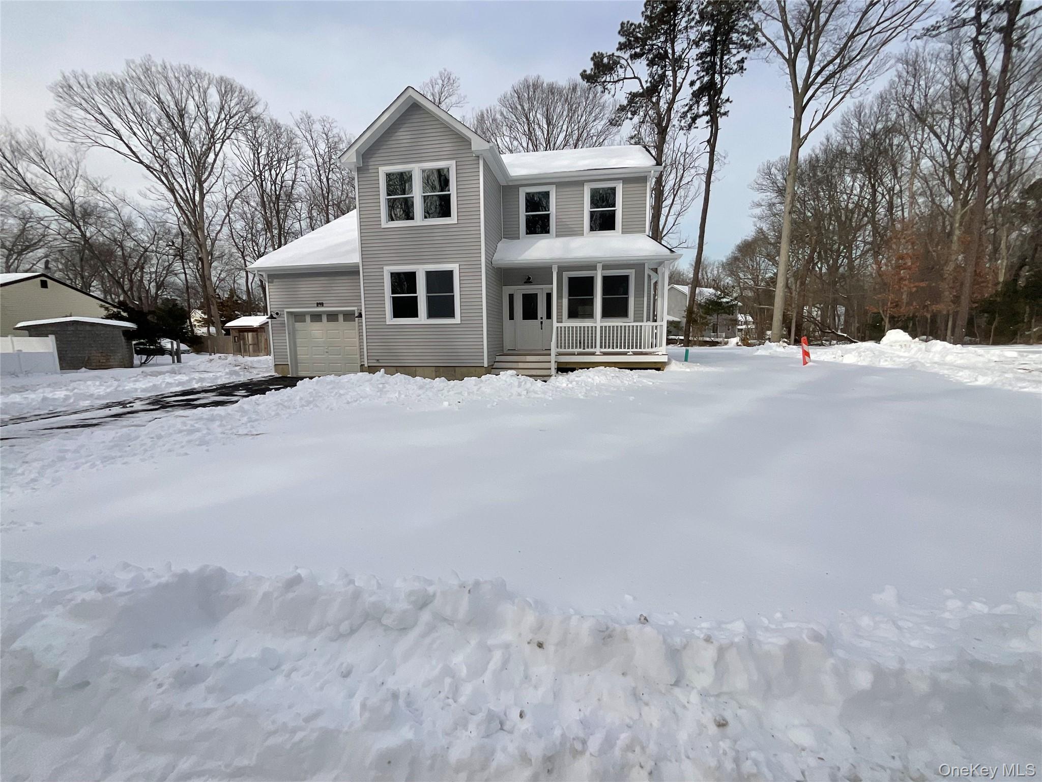 a front view of a house with a yard covered in snow