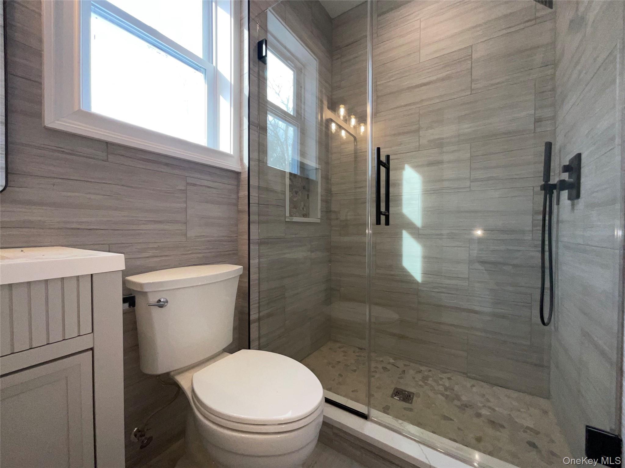 89 B Mount Sinai-Coram Road Coram, NY 11727 - Photo 13 of 23 a bathroom with a toilet and a shower