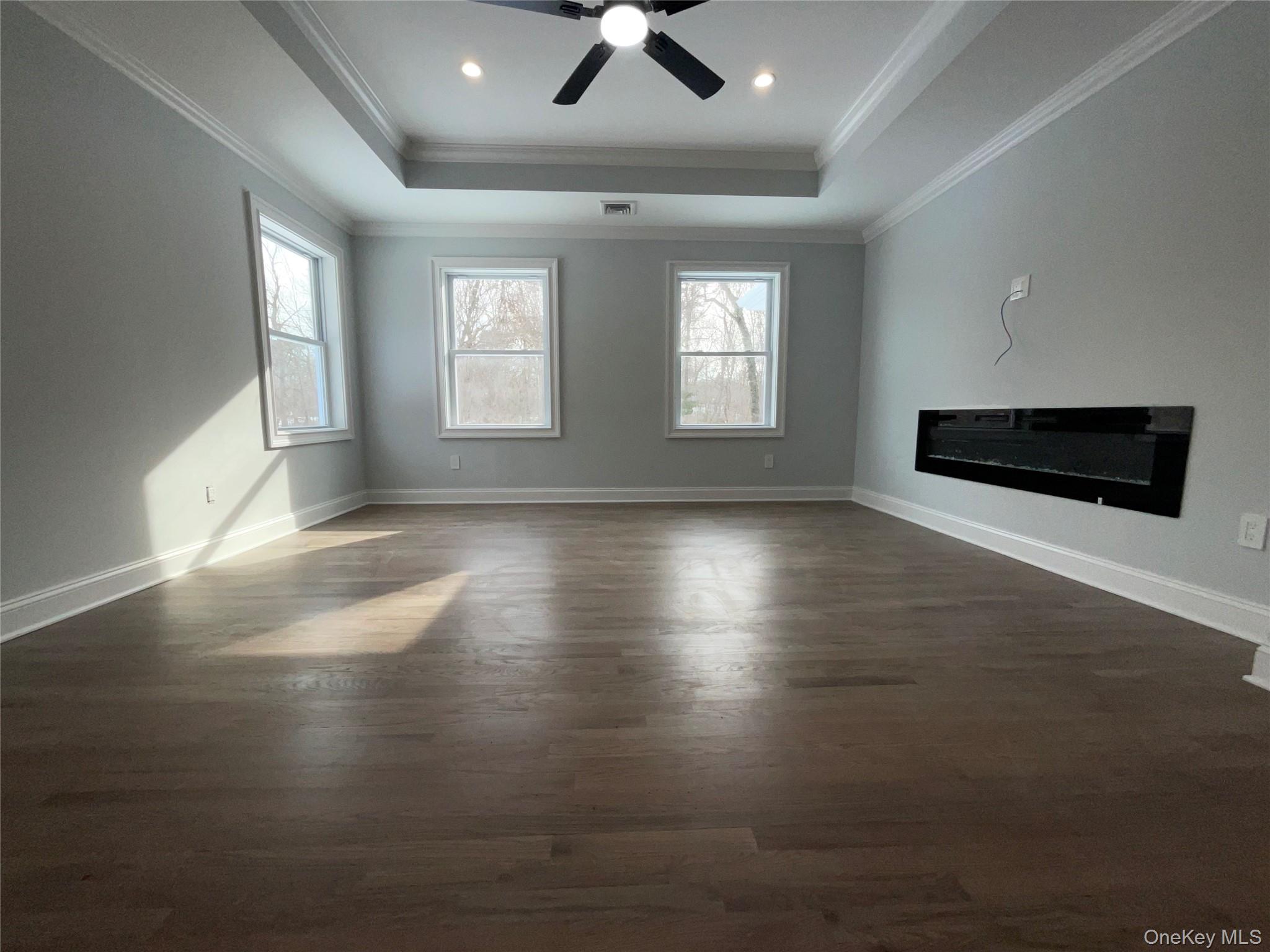 89 B Mount Sinai-Coram Road Coram, NY 11727 - Photo 14 of 23 a view of a livingroom with wooden floor and a ceiling fan