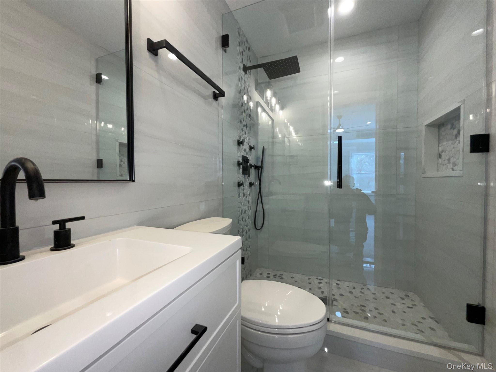 89 B Mount Sinai-Coram Road Coram, NY 11727 - Photo 18 of 23 a bathroom with a sink a toilet and shower