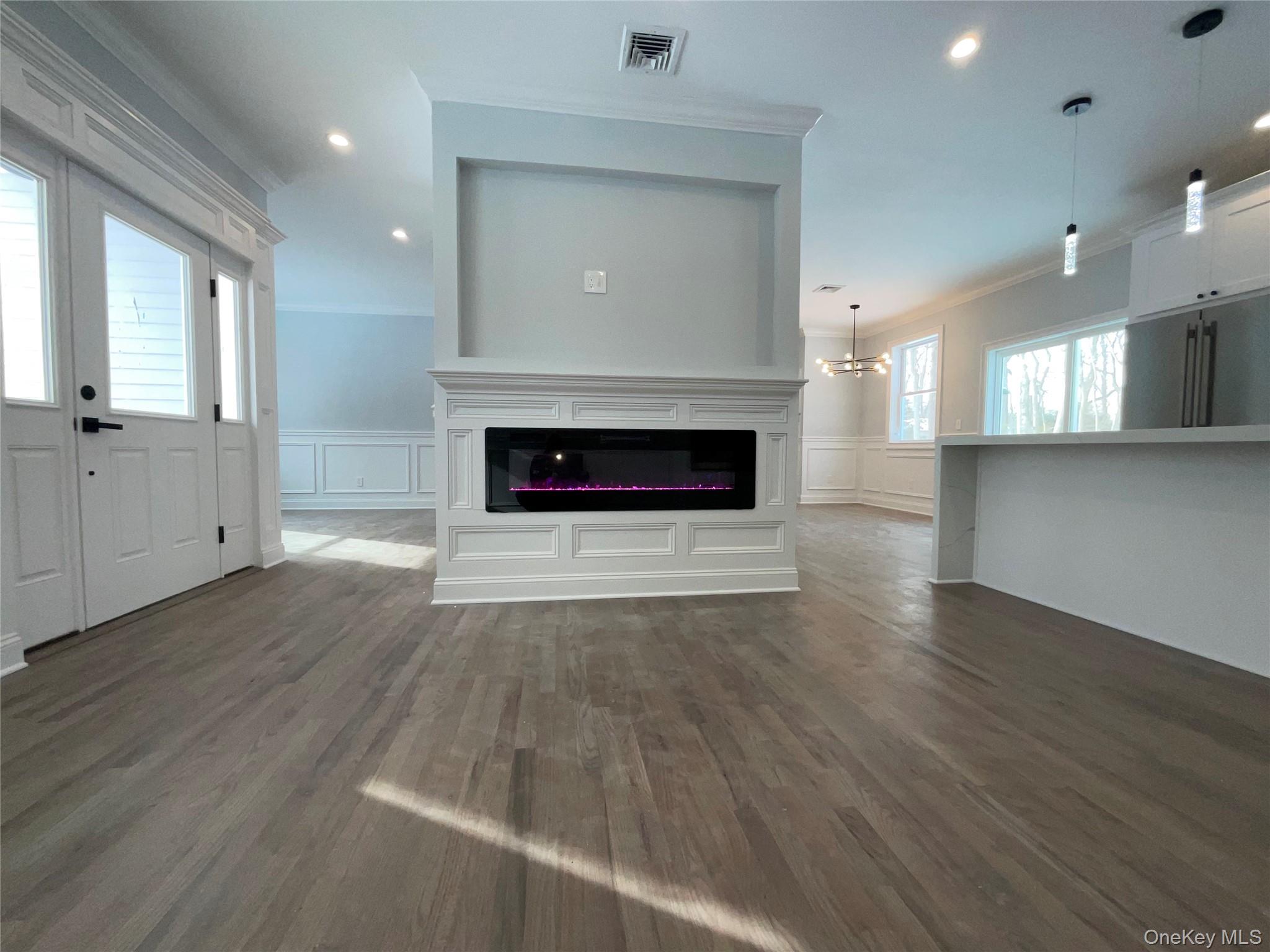 89 B Mount Sinai-Coram Road Coram, NY 11727 - Photo 6 of 23 an empty room with wooden floor a fireplace and windows