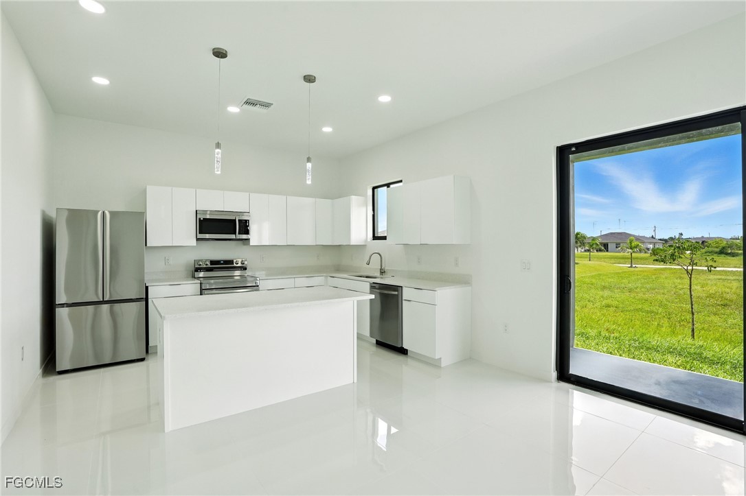 2725 Embers Parkway West Cape Coral, FL 33993 - Photo 11 of 32 a kitchen with stainless steel appliances a refrigerator a sink a stove top oven and a refrigerator
