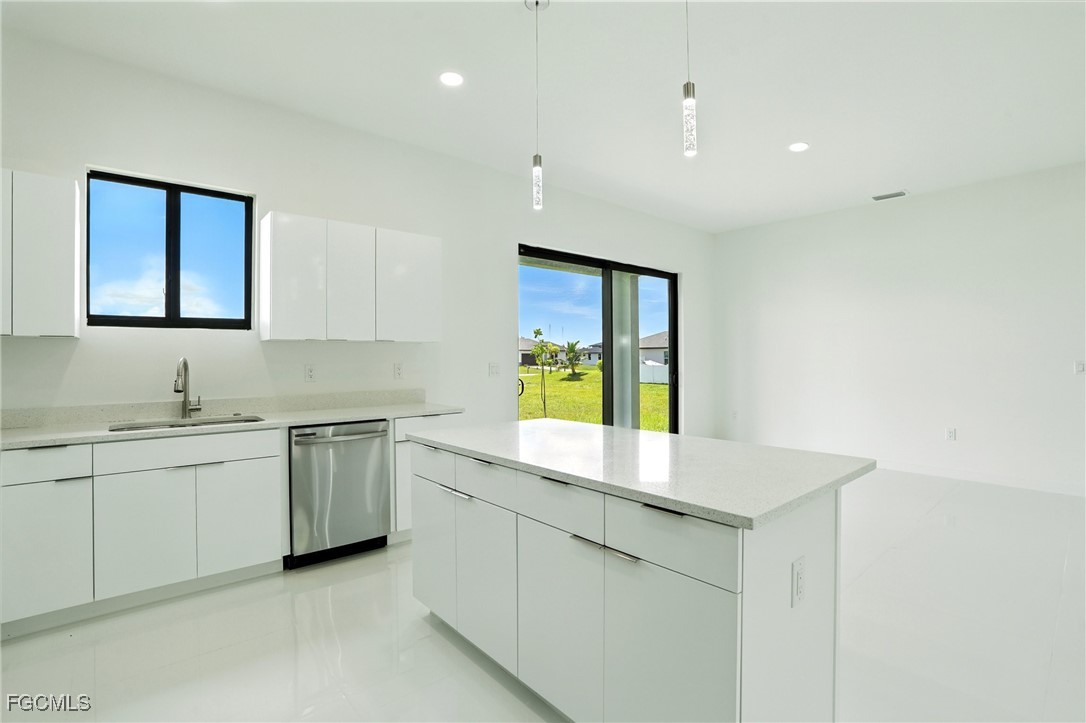 2725 Embers Parkway West Cape Coral, FL 33993 - Photo 12 of 32 a kitchen with granite countertop a sink and white cabinets