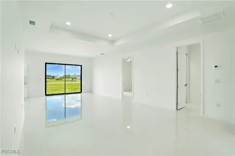 en empty room with glass door and chandelier