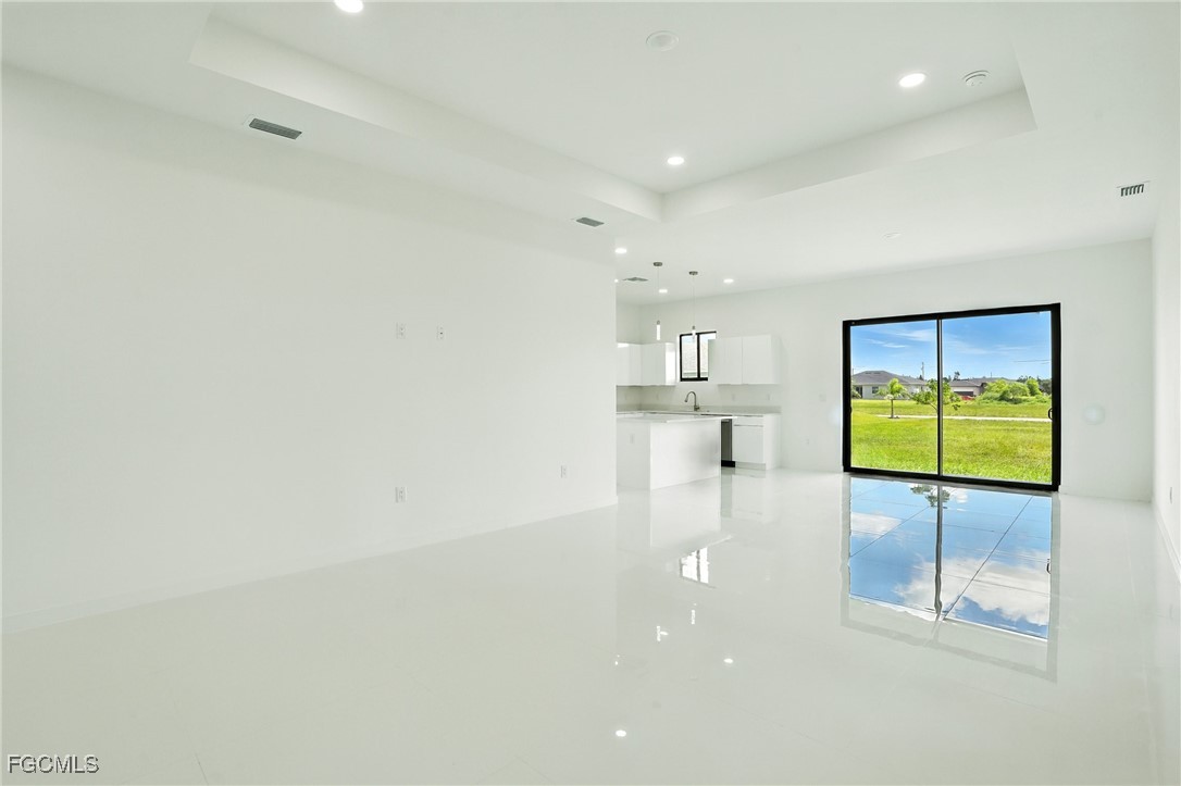 2725 Embers Parkway West Cape Coral, FL 33993 - Photo 5 of 32 en empty room with glass door and chandelier
