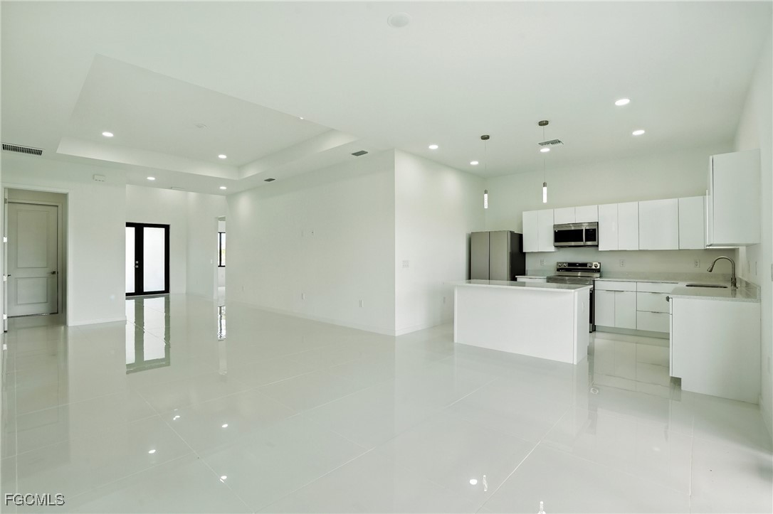 2725 Embers Parkway West Cape Coral, FL 33993 - Photo 7 of 32 a view of kitchen with stainless steel appliances refrigerator stove microwave and white cabinets