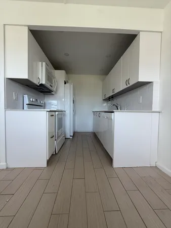 a kitchen with a cabinets and white appliances