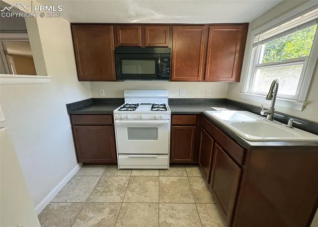 a kitchen with a sink stove and microwave