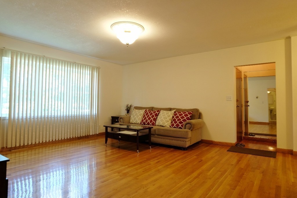 157 Lake Shore Road, Unit 2 Boston, MA 02135 - Photo 17 of 28 a living room with furniture and a wooden floor