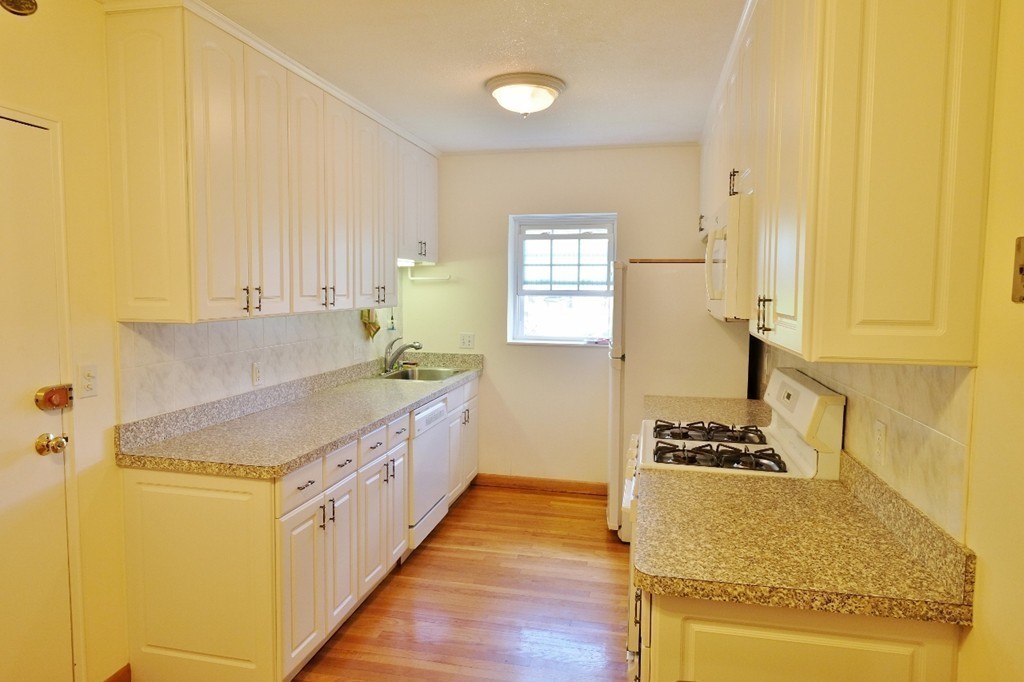 157 Lake Shore Road, Unit 2 Boston, MA 02135 - Photo 19 of 28 a kitchen with stainless steel appliances granite countertop a sink and cabinets