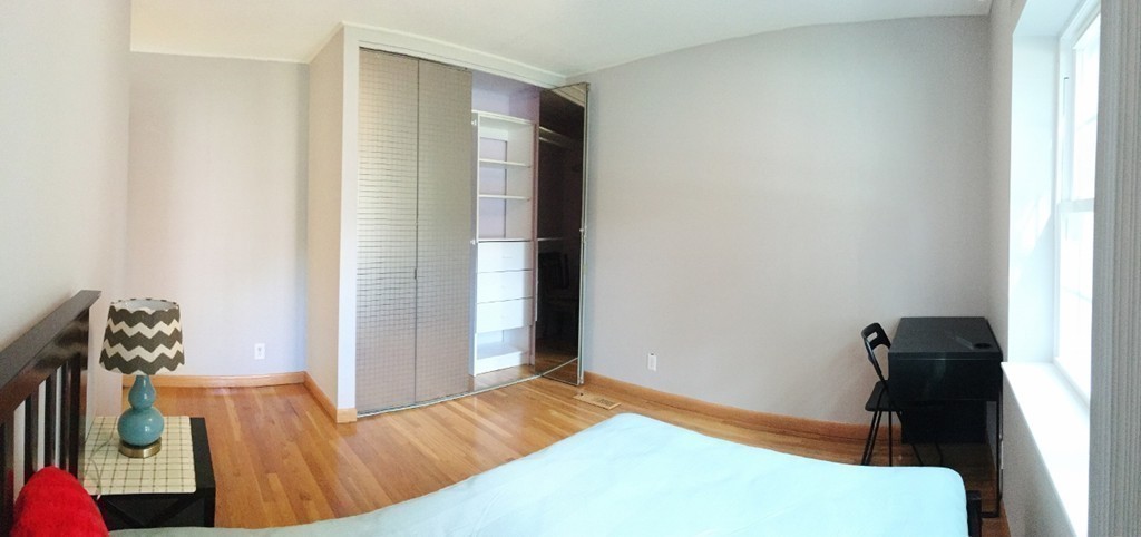 157 Lake Shore Road, Unit 2 Boston, MA 02135 - Photo 26 of 28 a bedroom with a bed and wooden floor