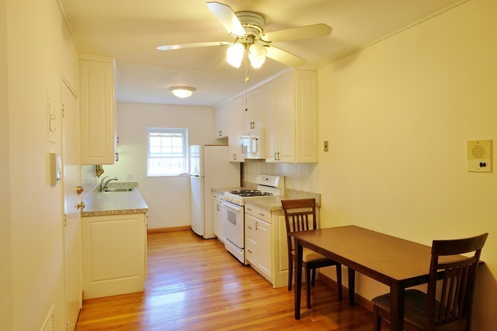 157 Lake Shore Road, Unit 2 Boston, MA 02135 - Photo 4 of 28 a kitchen with stainless steel appliances granite countertop a sink a stove a refrigerator cabinets and wooden floor