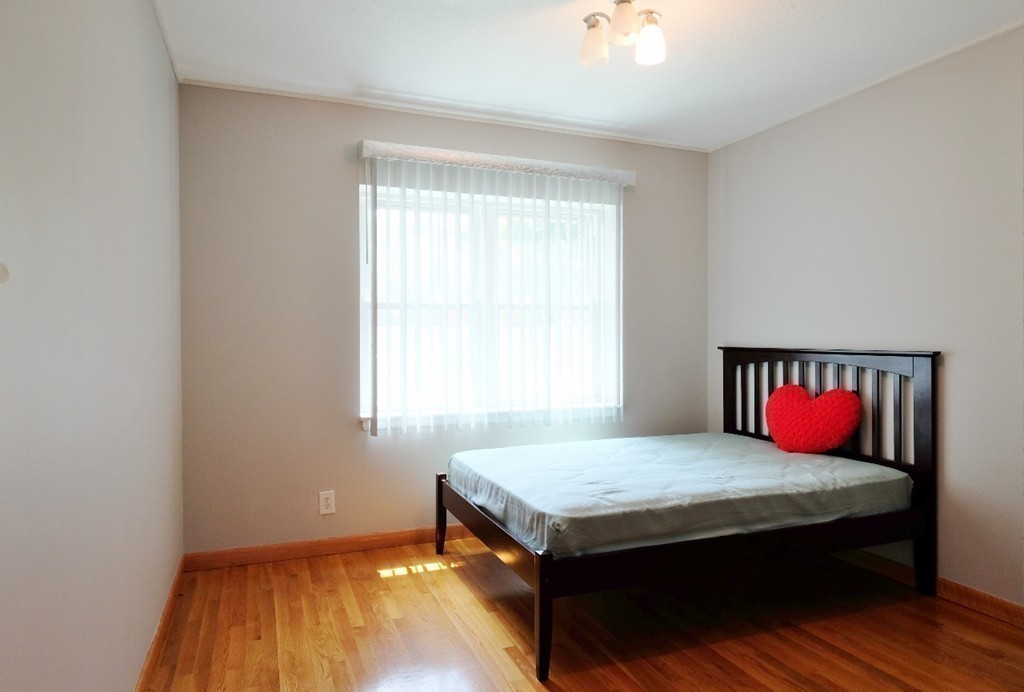 157 Lake Shore Road, Unit 2 Boston, MA 02135 - Photo 6 of 28 a bed sitting in a bedroom next to a window