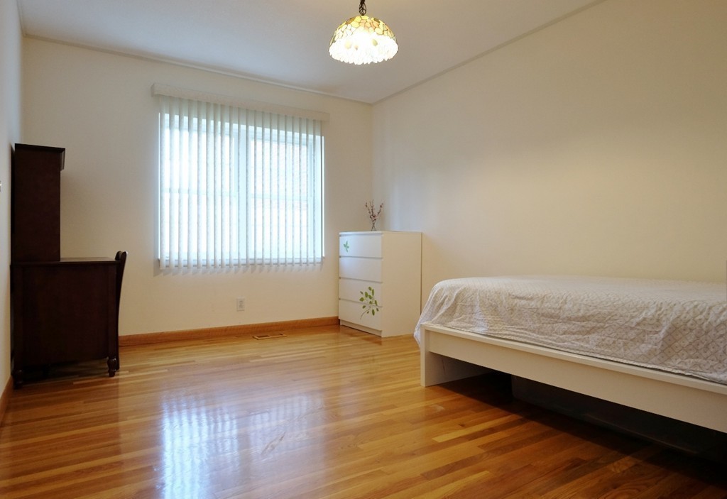 157 Lake Shore Road, Unit 2 Boston, MA 02135 - Photo 7 of 28 a bedroom with a bed and a window