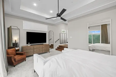 a bedroom with a bed a couch and a flat screen tv