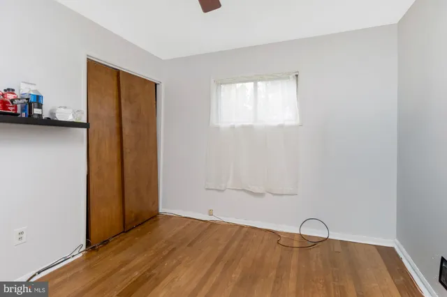 a view of a livingroom with wooden floor and ceiling fan