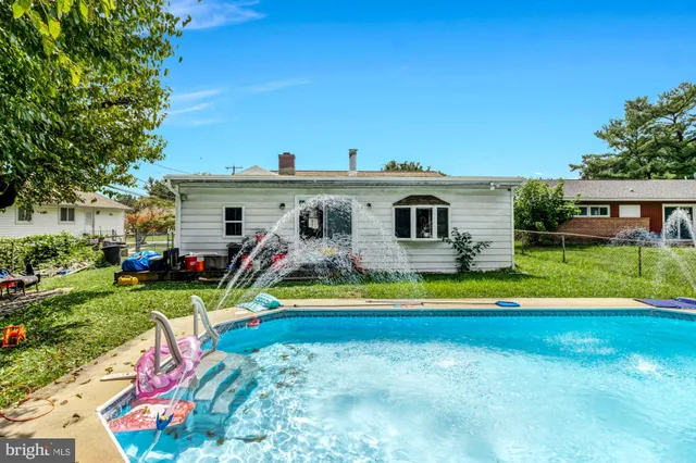 a view of a house with swimming pool and a yard