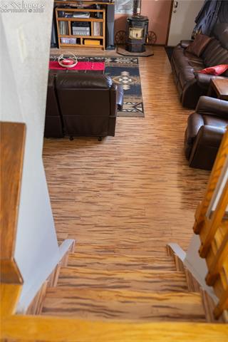 8115 Mustang Road Colorado Springs, CO 80908 - Photo 21 of 48 Living room featuring light wood-style flooring and a wood stove