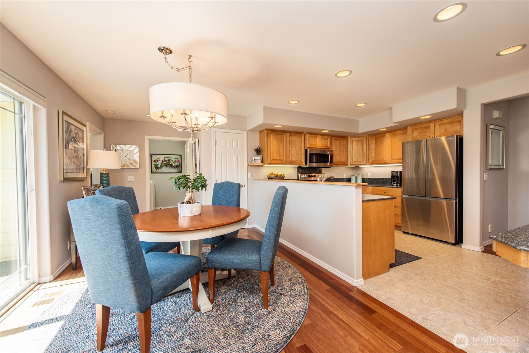 170 Donaper Road Sequim, WA 98382 - Photo 15 of 40 a dining room with stainless steel appliances a dining table wooden floor and a chandelier