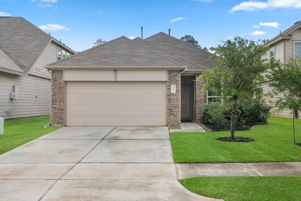 a front view of a house with a garden and garage
