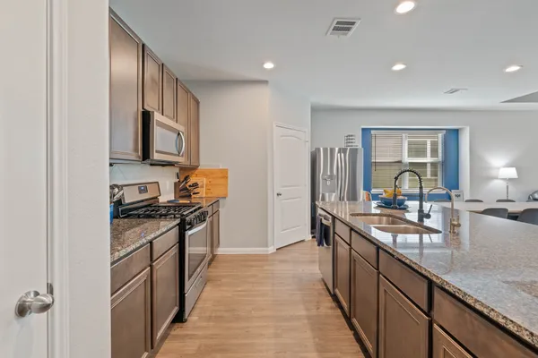 a kitchen with granite countertop lots of counter top space and stainless steel appliances
