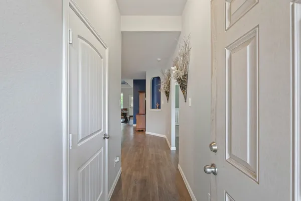 a view of a hallway with wooden floor and closet area