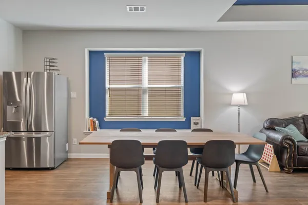 a kitchen with stainless steel appliances granite countertop a table chairs and a refrigerator