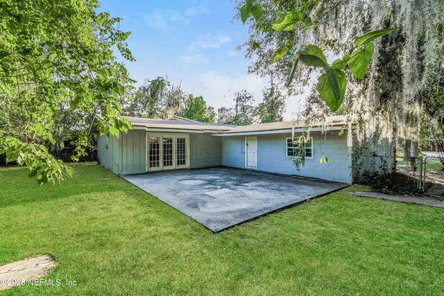 front view of house with a yard and potted plants