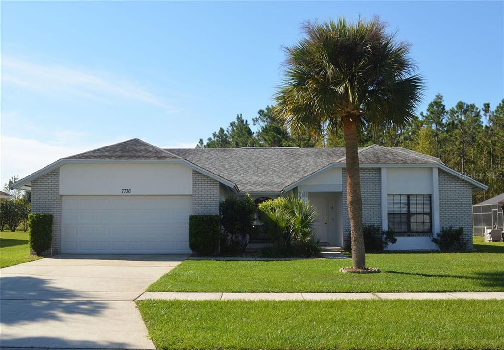 7736 Indian Ridge Trail South Kissimmee, FL 34747 - Photo 1 of 1 a front view of a house with a yard and garage