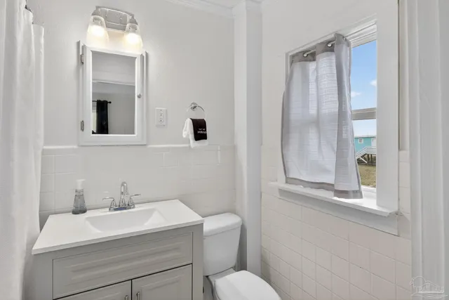 a bathroom with a sink and mirror with toilet