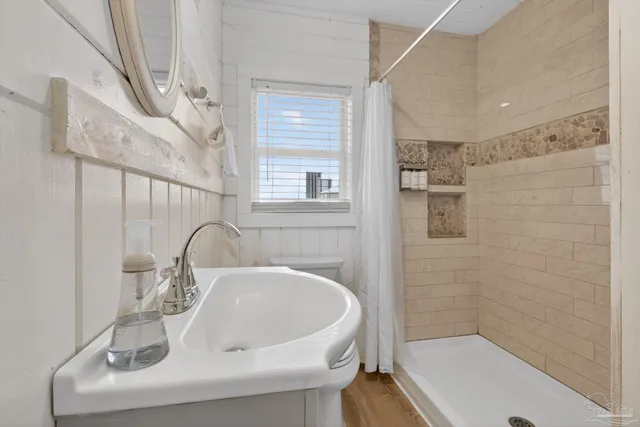 a bathroom with a sink a toilet and shower