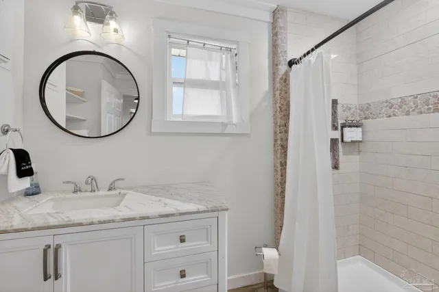 a bathroom with a granite countertop toilet a sink and a mirror