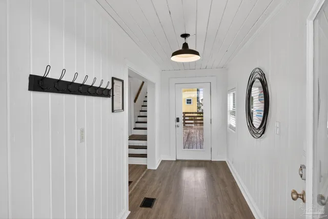 a view of a room with wooden floor and entryway