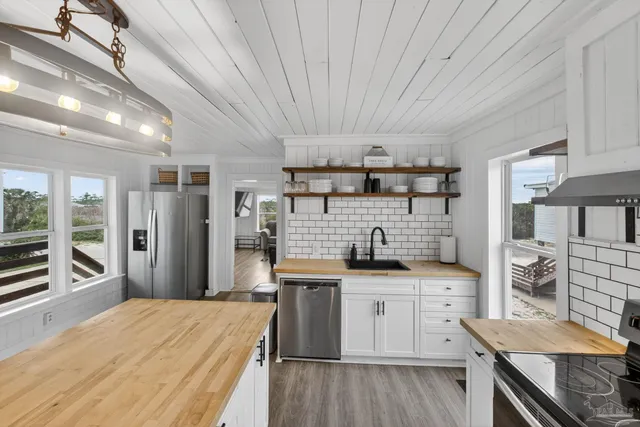 a kitchen with stainless steel appliances kitchen island granite countertop a sink stove and refrigerator