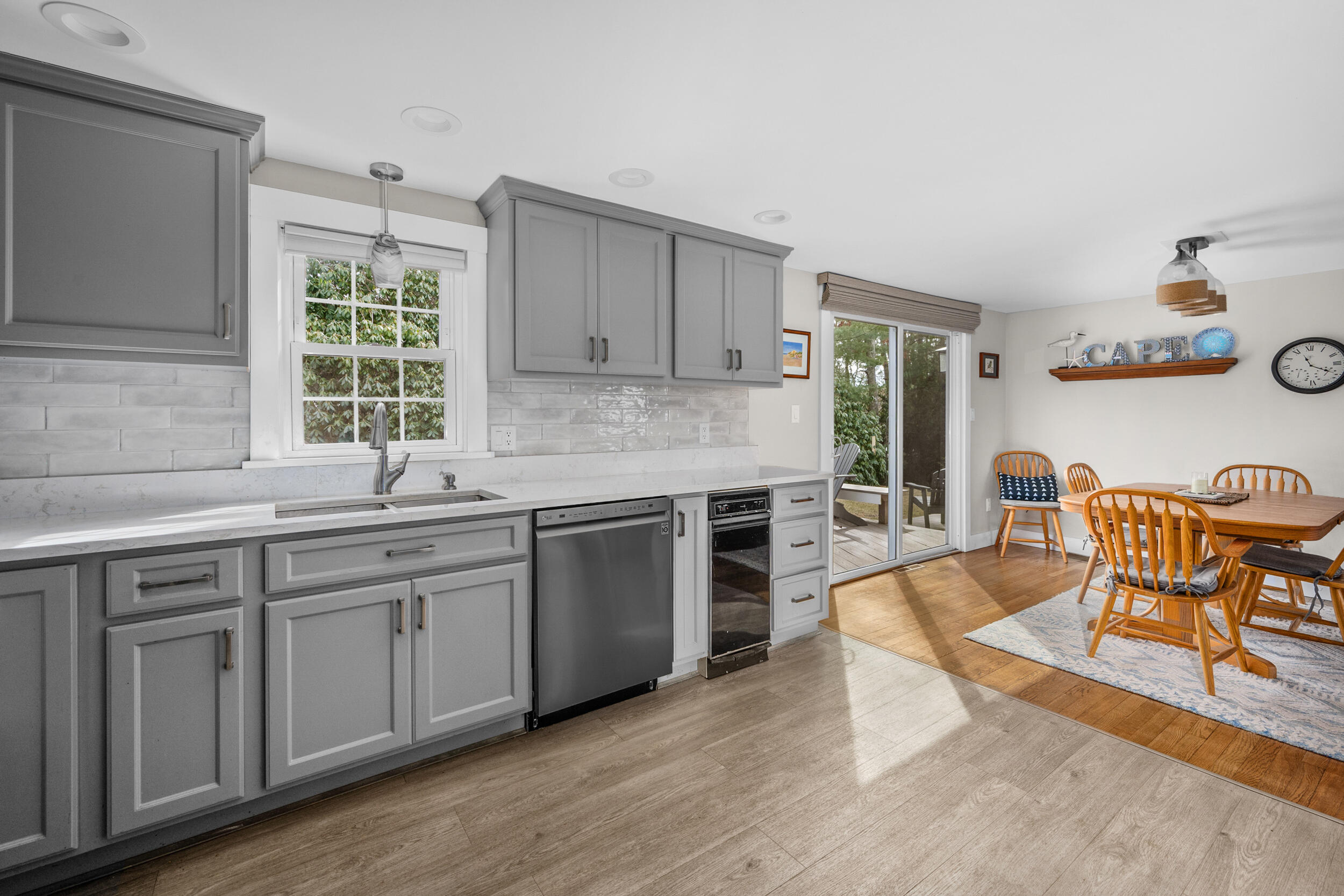 110 Fuller Road Centerville, MA 02632 - Photo 4 of 23 a kitchen with stainless steel appliances granite countertop a table chairs in it and wooden floors