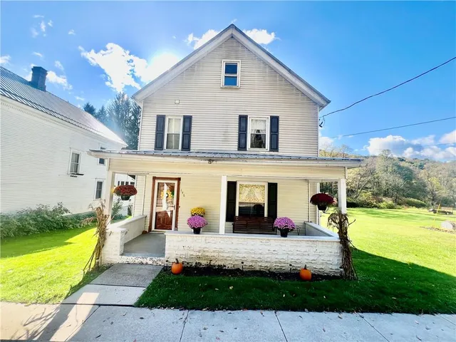 a group of people sitting in front of a house with swimming pool