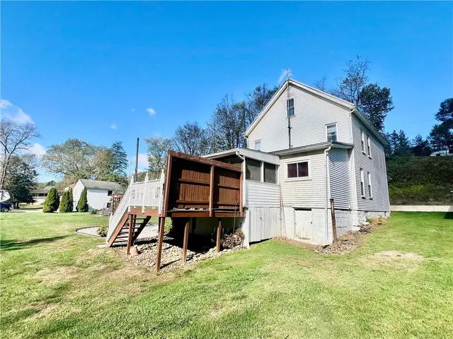 a view of a house with yard and deck