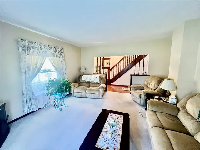 a living room with furniture and a painting on the wall