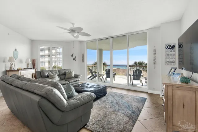 a living room with furniture a flat screen tv and a large window