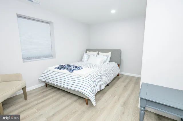 a spacious bedroom with a bed and a chair